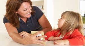 Young girl being shown card by smiling woman